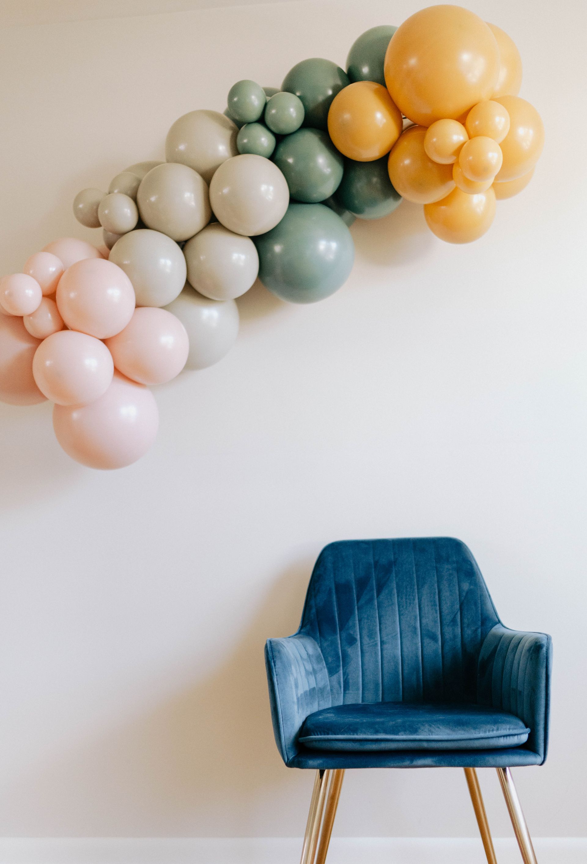 a blue chair is sitting in front of a wall with balloons on it