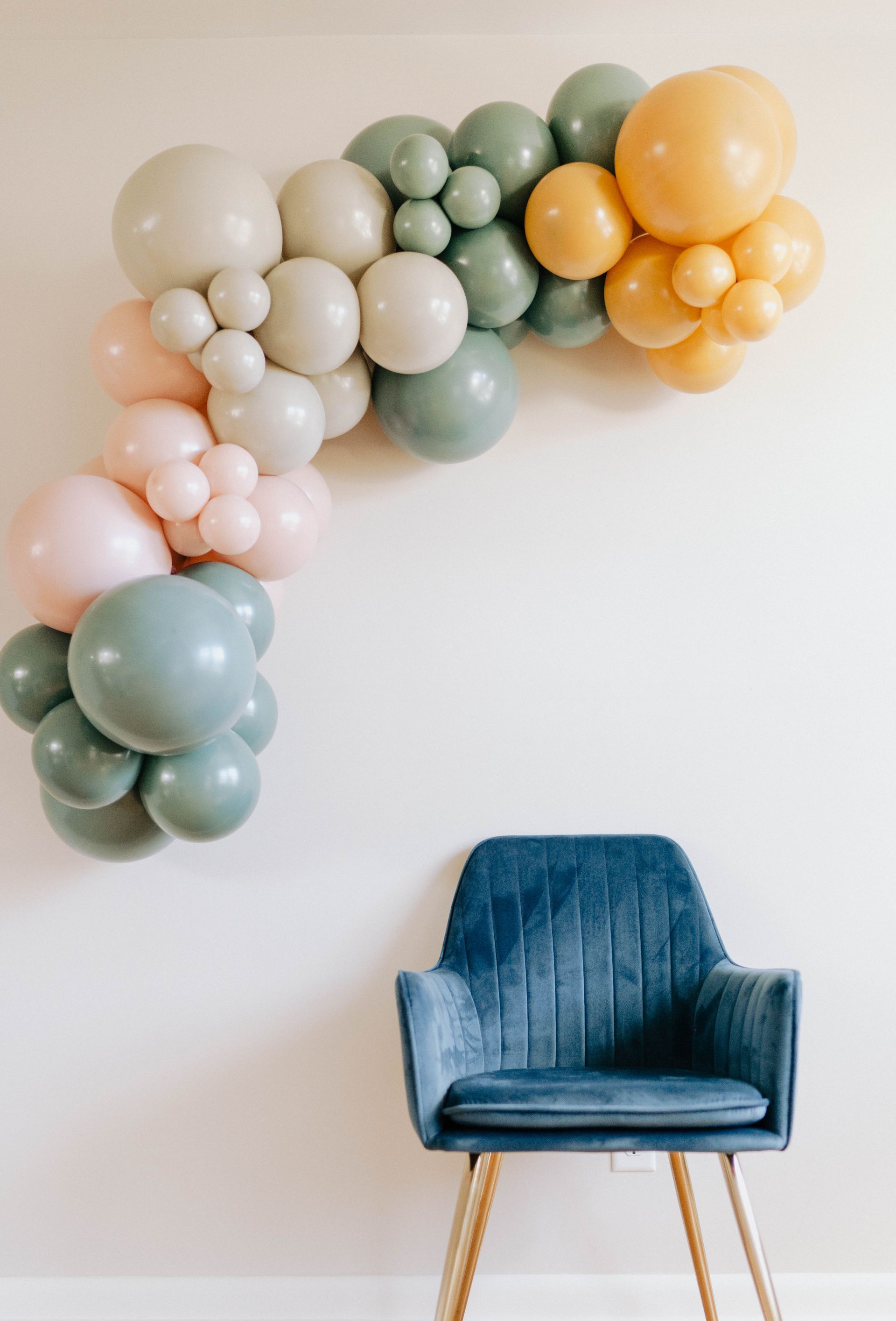a chair is sitting in front of a wall with balloons on it