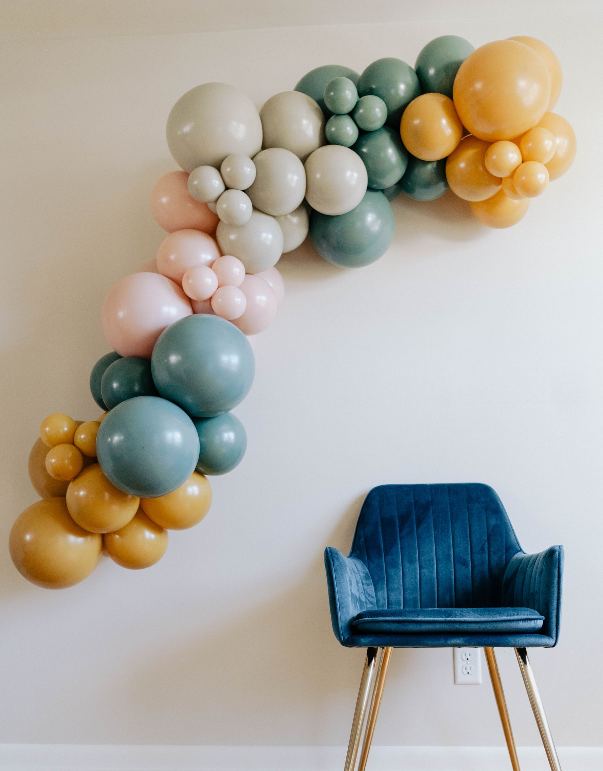 a chair is sitting in front of a wall with balloons on it