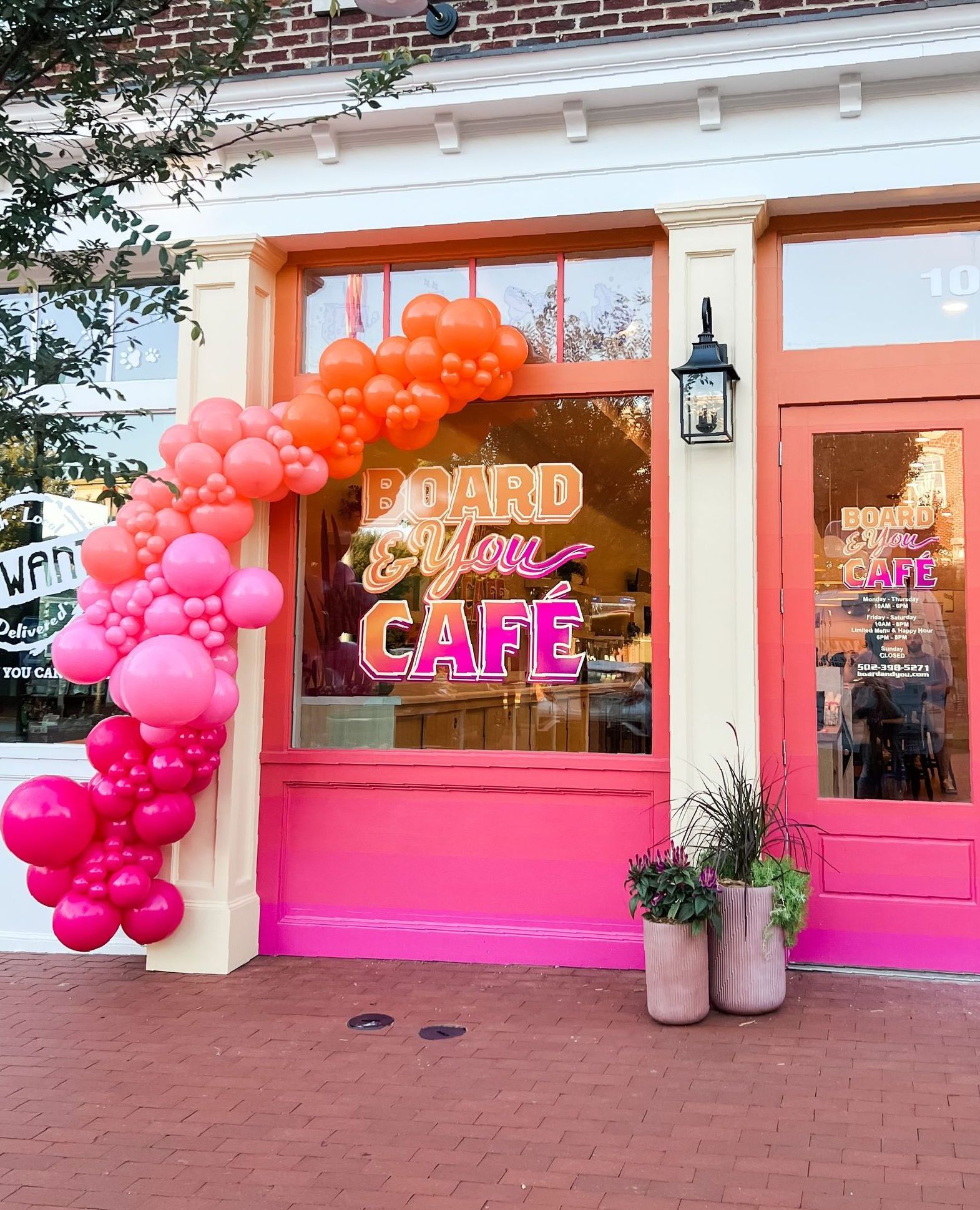 a pink and orange building with balloons in front of it
