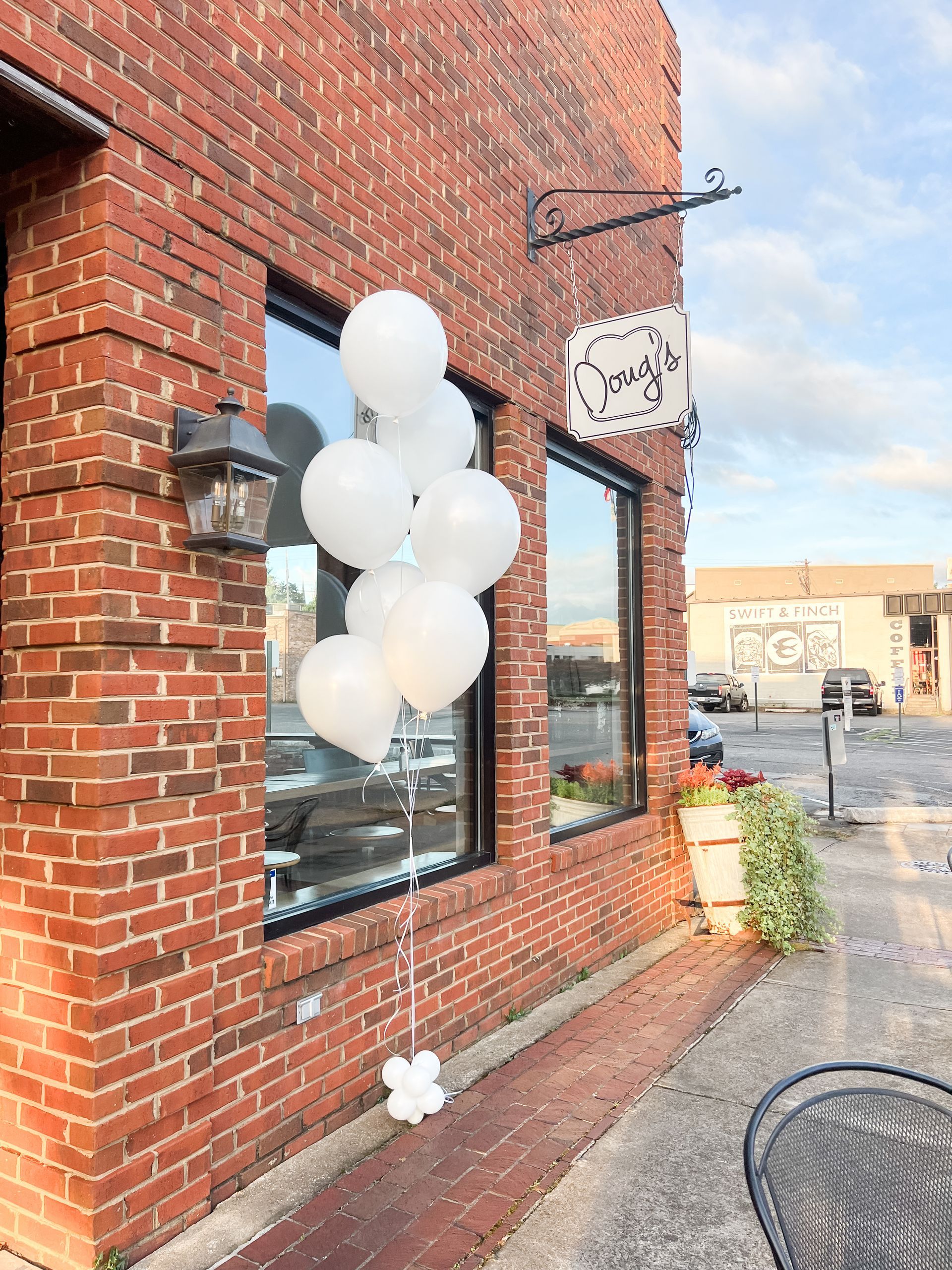White helium balloon bouquet outside of a restaurant