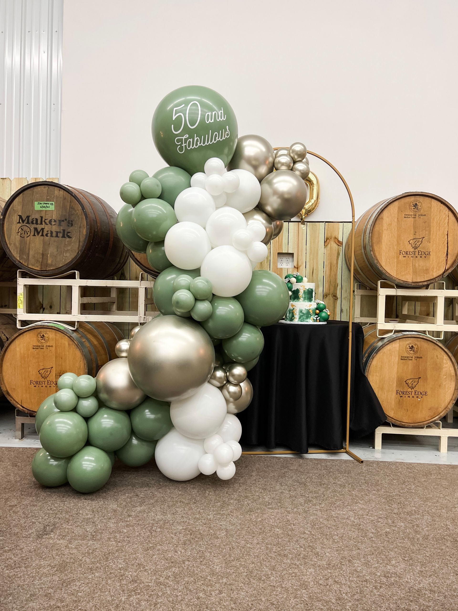 a bunch of balloons are sitting on a table in front of barrels