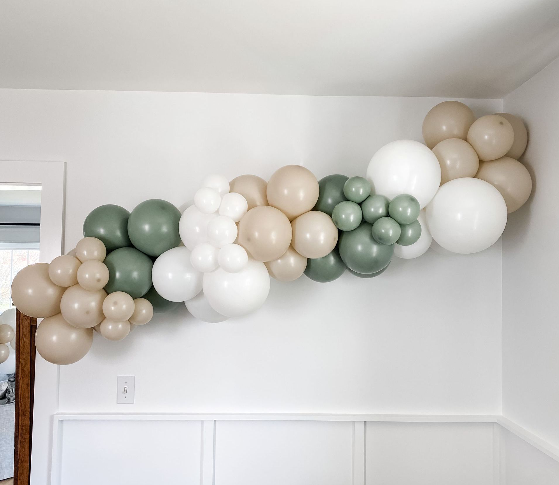organic balloon garland hung on a wall