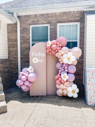 a brick building with balloons and flowers in front of it