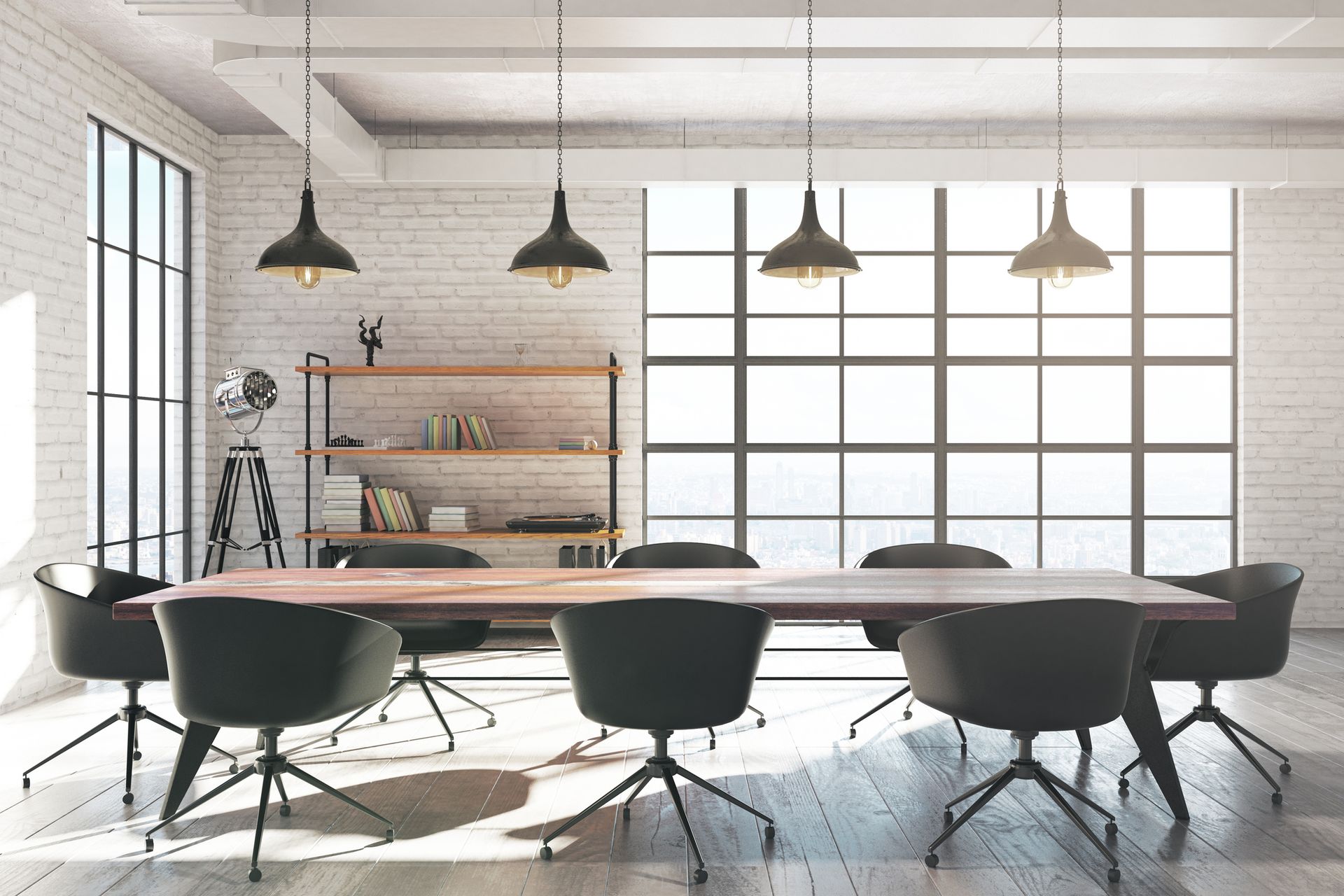 Modern office conference room with large wooden table, chairs, and hanging lights.