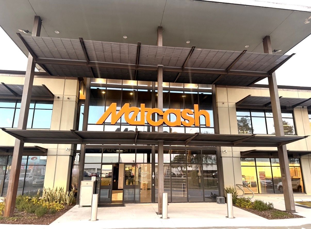McIntosh storefront with orange logo and glass entrance under a modern canopy