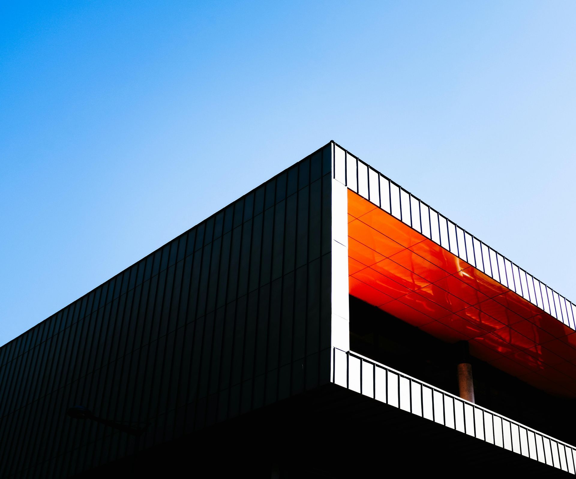 A building with a balcony and a blue sky in the background