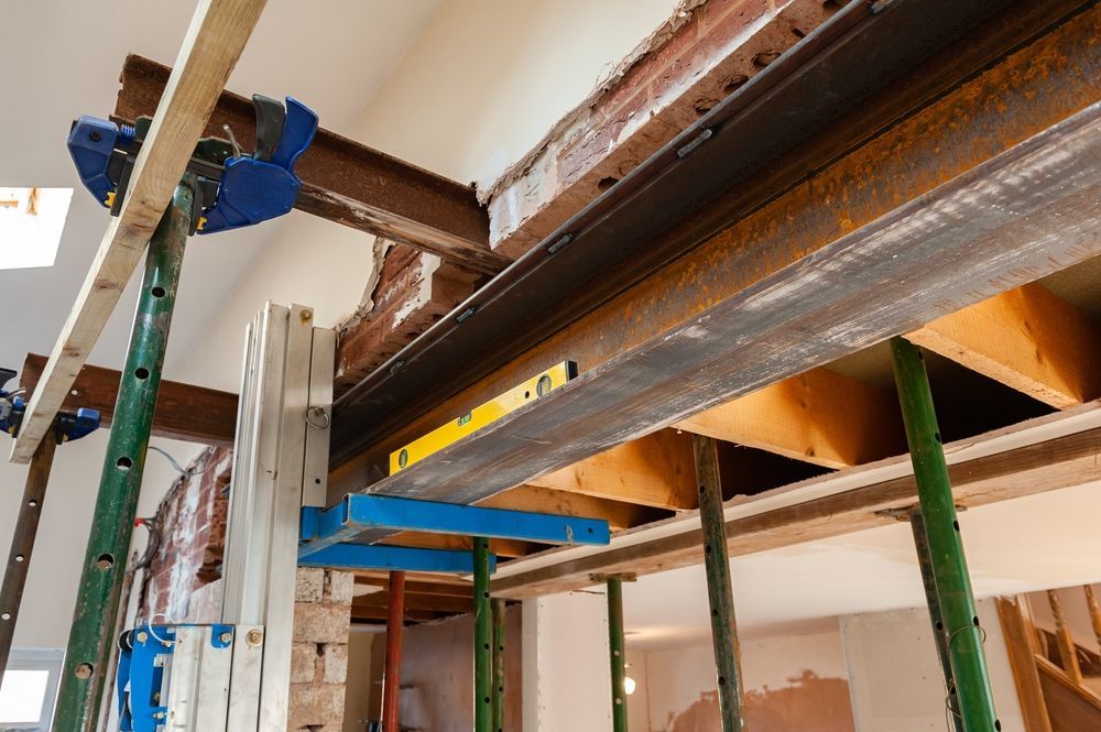 A Ladder is Sitting Under a Metal Beam in a Building Under Construction — Dynamic Services in Yeppoon, QLD