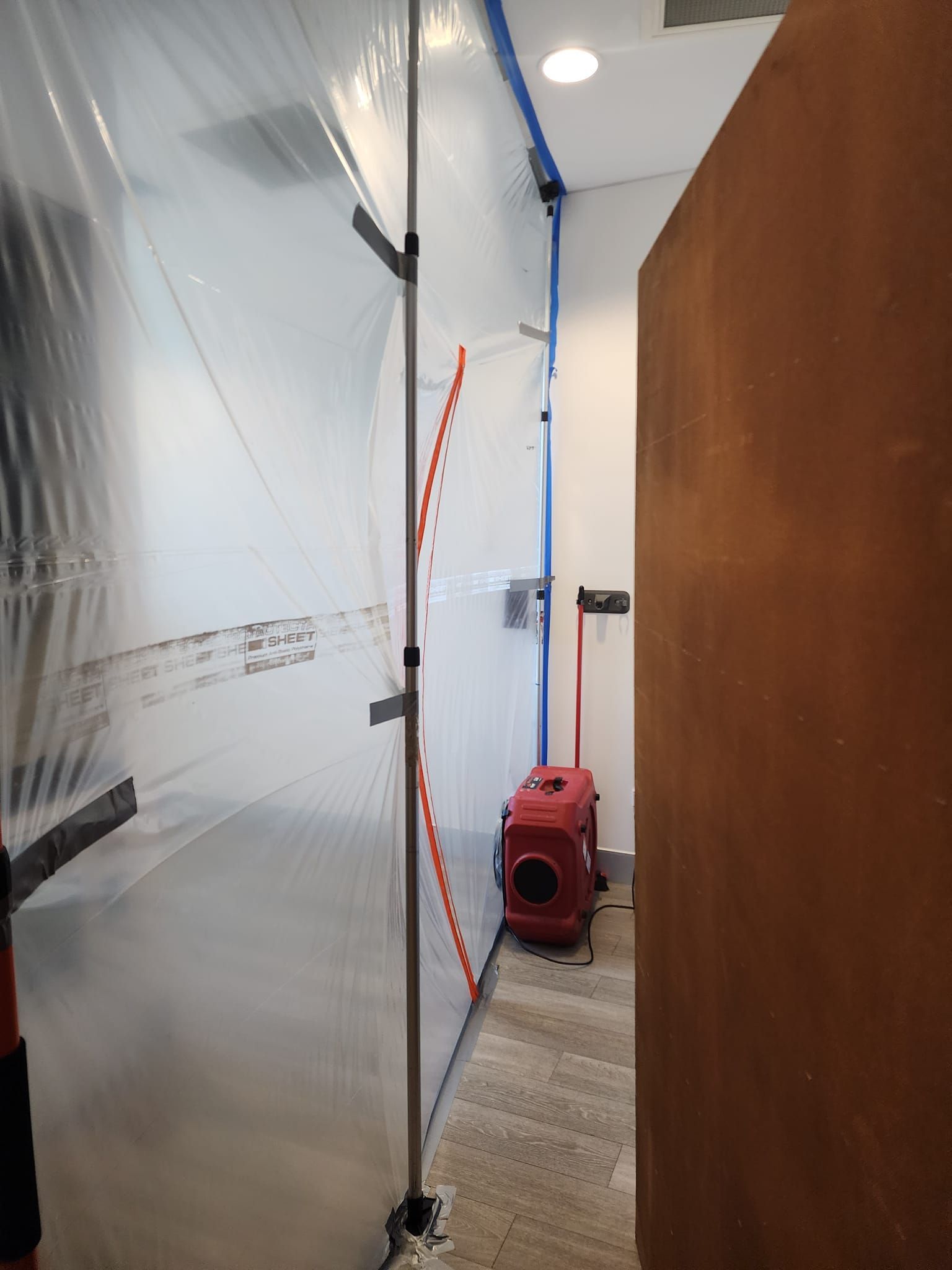 A Person is Cleaning a Corner of a Wall With a Spray Bottle — Dynamic Services in Limestone Creek, QLD