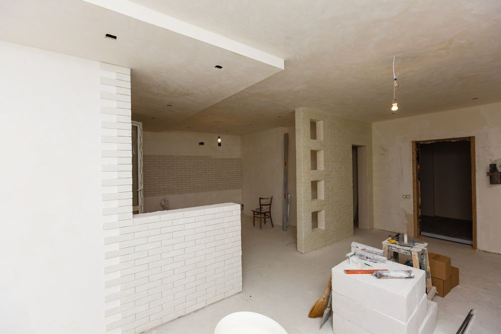 A Room That is Being Remodeled With White Walls and a Brick Wall — Dynamic Services in Yeppoon, QLD