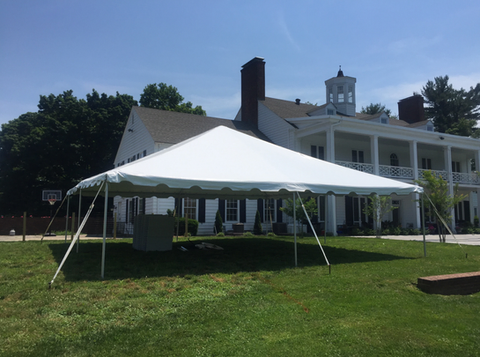 White event tent on a grassy lawn in front of a large white historic house on a sunny day