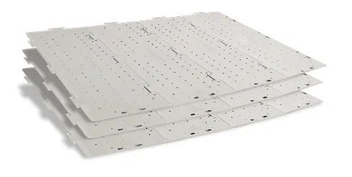Stack of white perforated acoustic ceiling panels on a white background