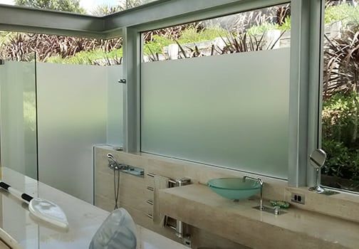 Bathroom with frosted glass windows and a stone countertop.