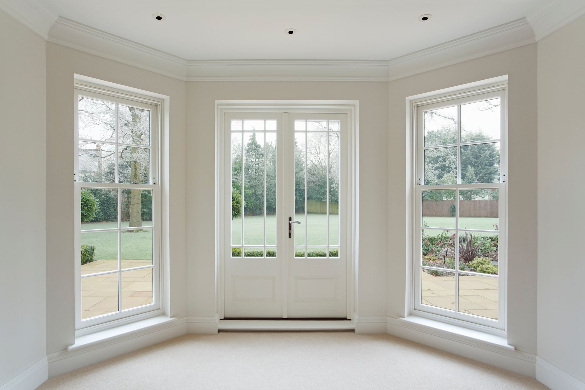 An empty room with a lot of windows and a door.