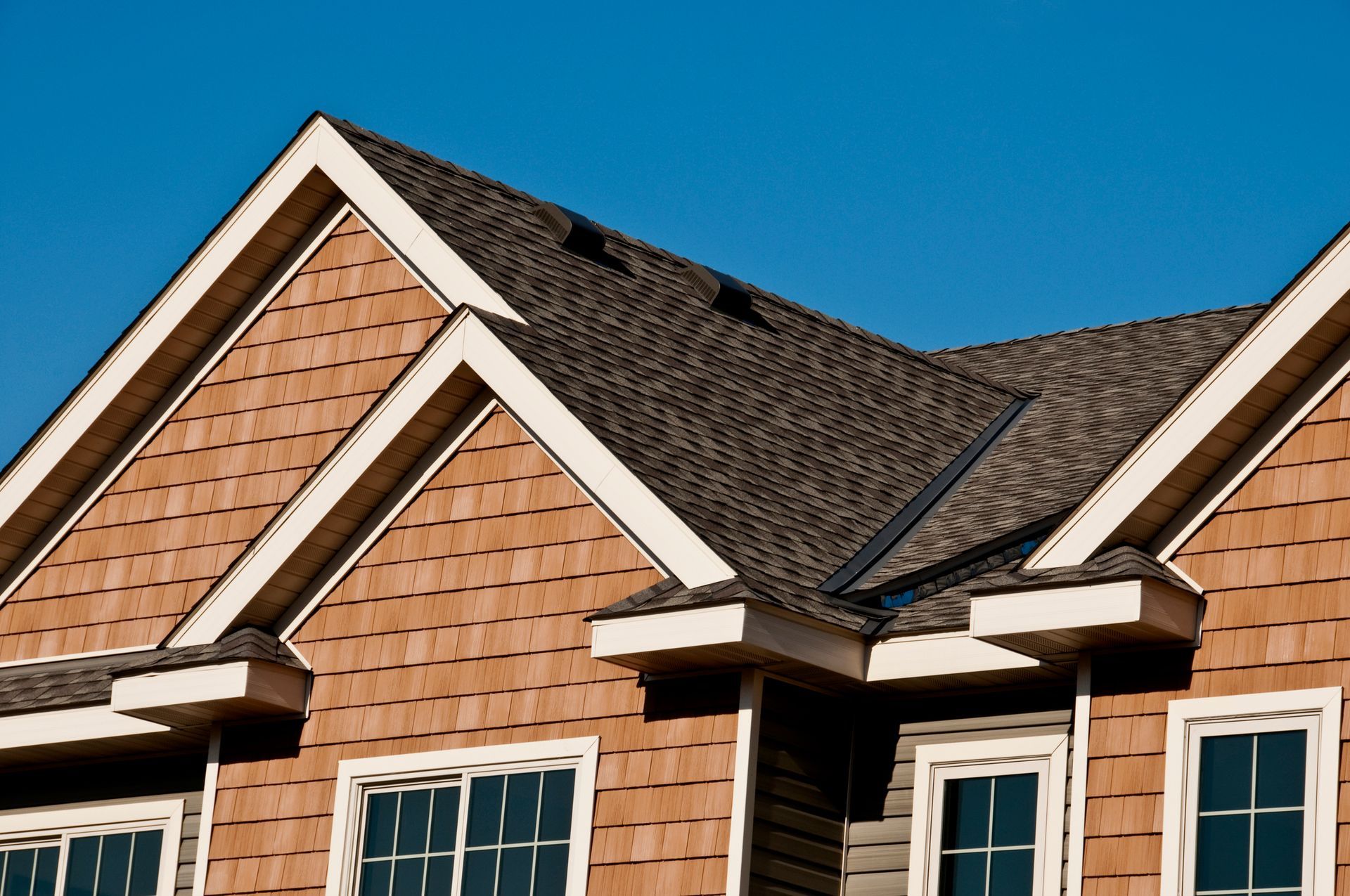 The roof of a house with a blue sky in the background.