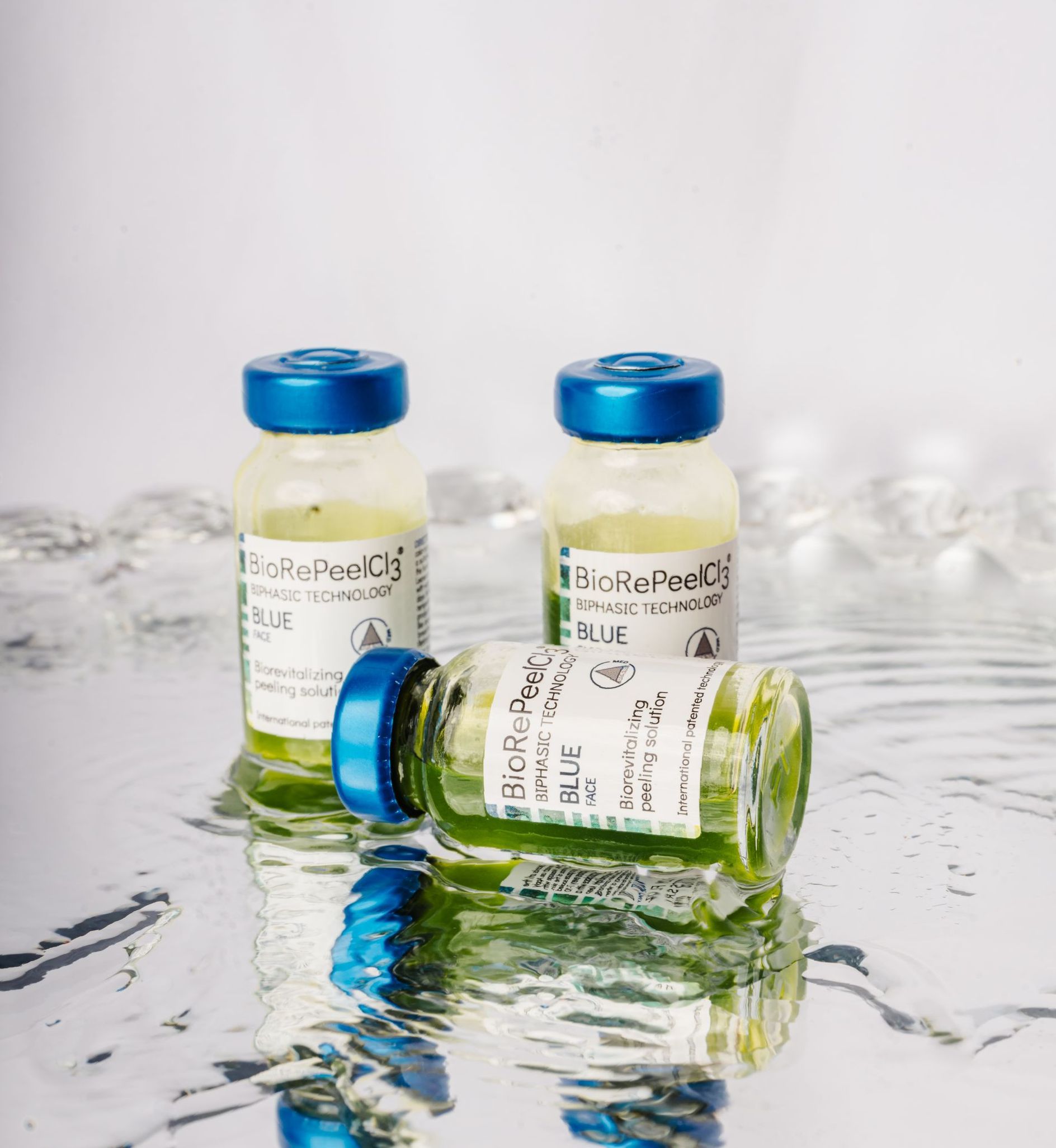 Three bottles of liquid are sitting on top of a silver surface.