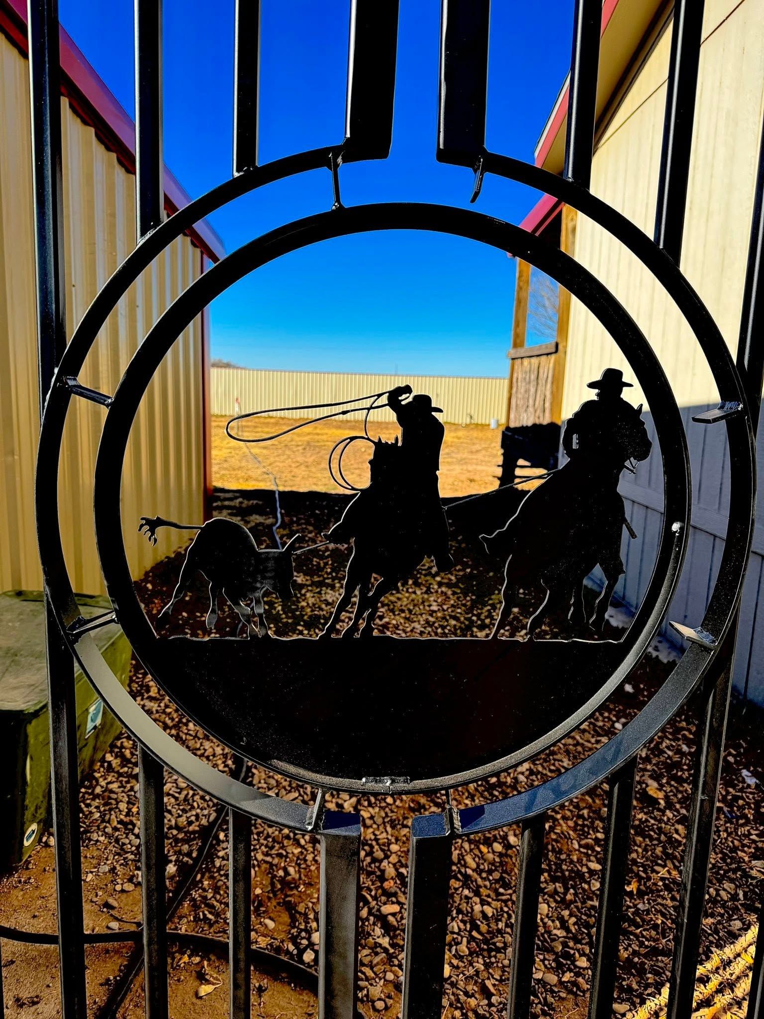 Black circular metal sculpture framing a sunny desert scene with two animal silhouettes and a blue sky