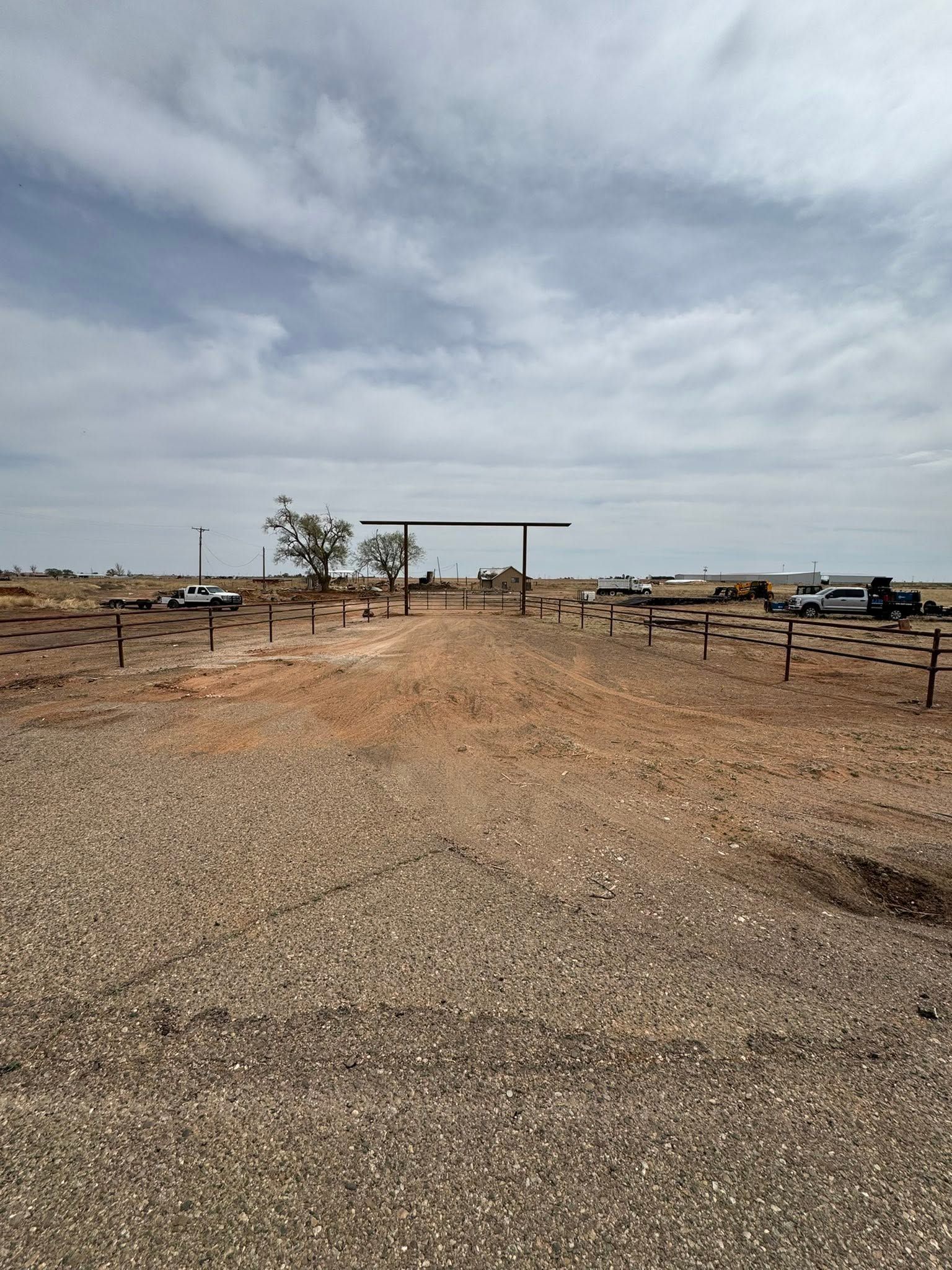 Sparse desert campsite with picnic tables and a small shelter under a cloudy sky