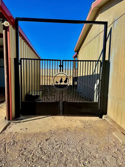 Gated entrance to a narrow passage between tan walls under a bright blue sky