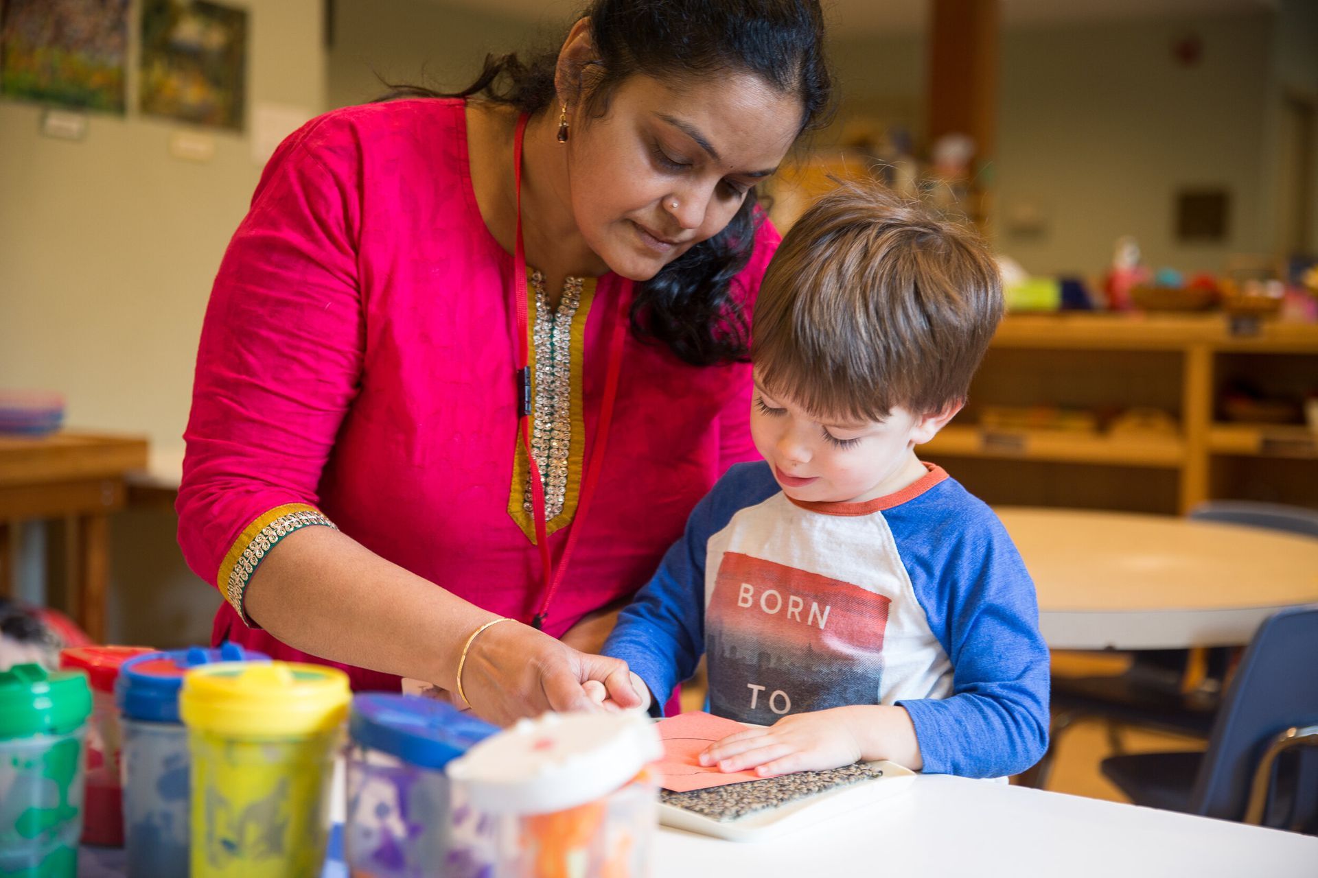 Guide observing child's work with Montessori materials