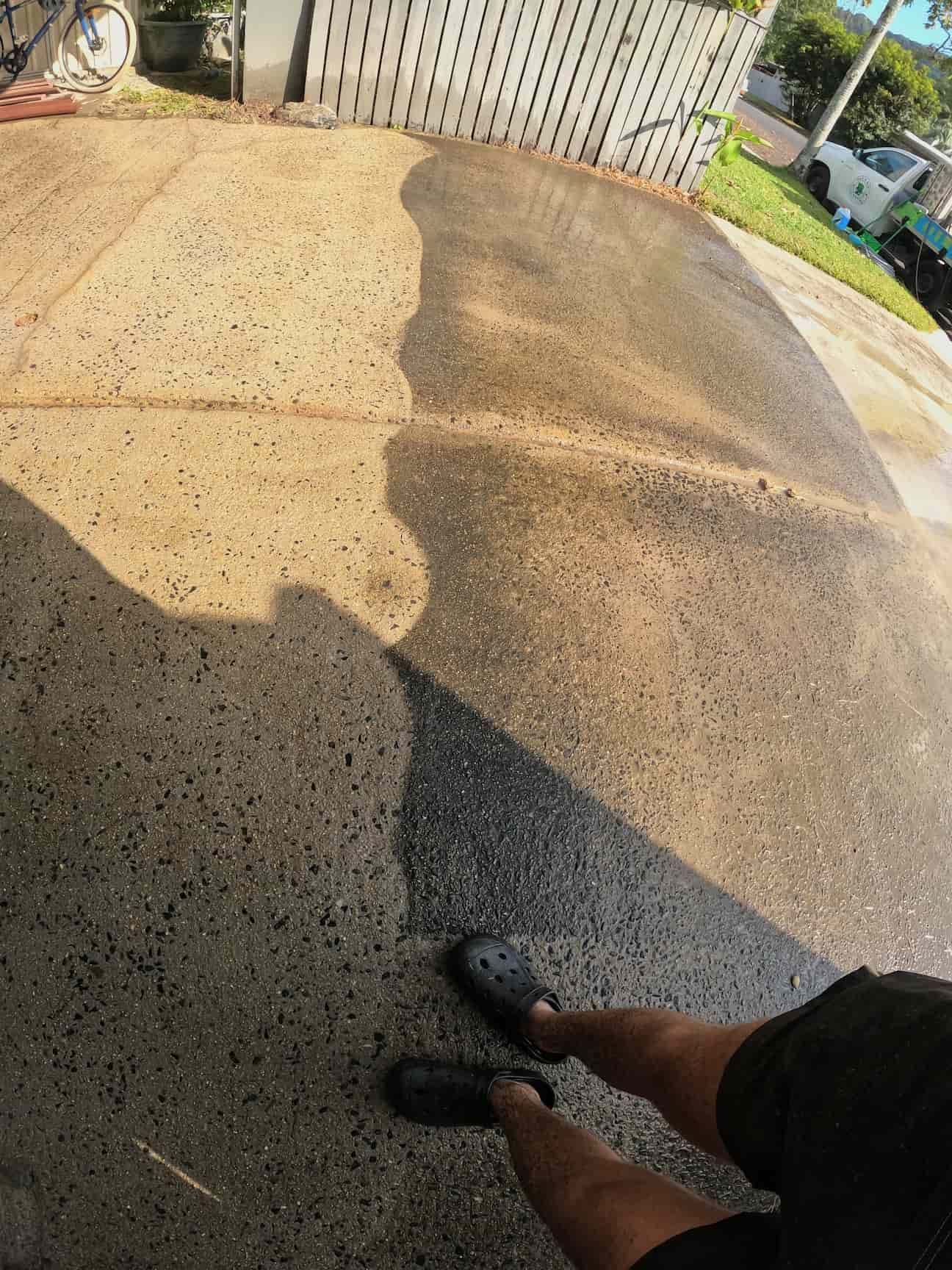 Person Pressure Washing a Brick Patio Near a Teal Car — Cairns Bin Cleaning In Parramatta Park, QLD