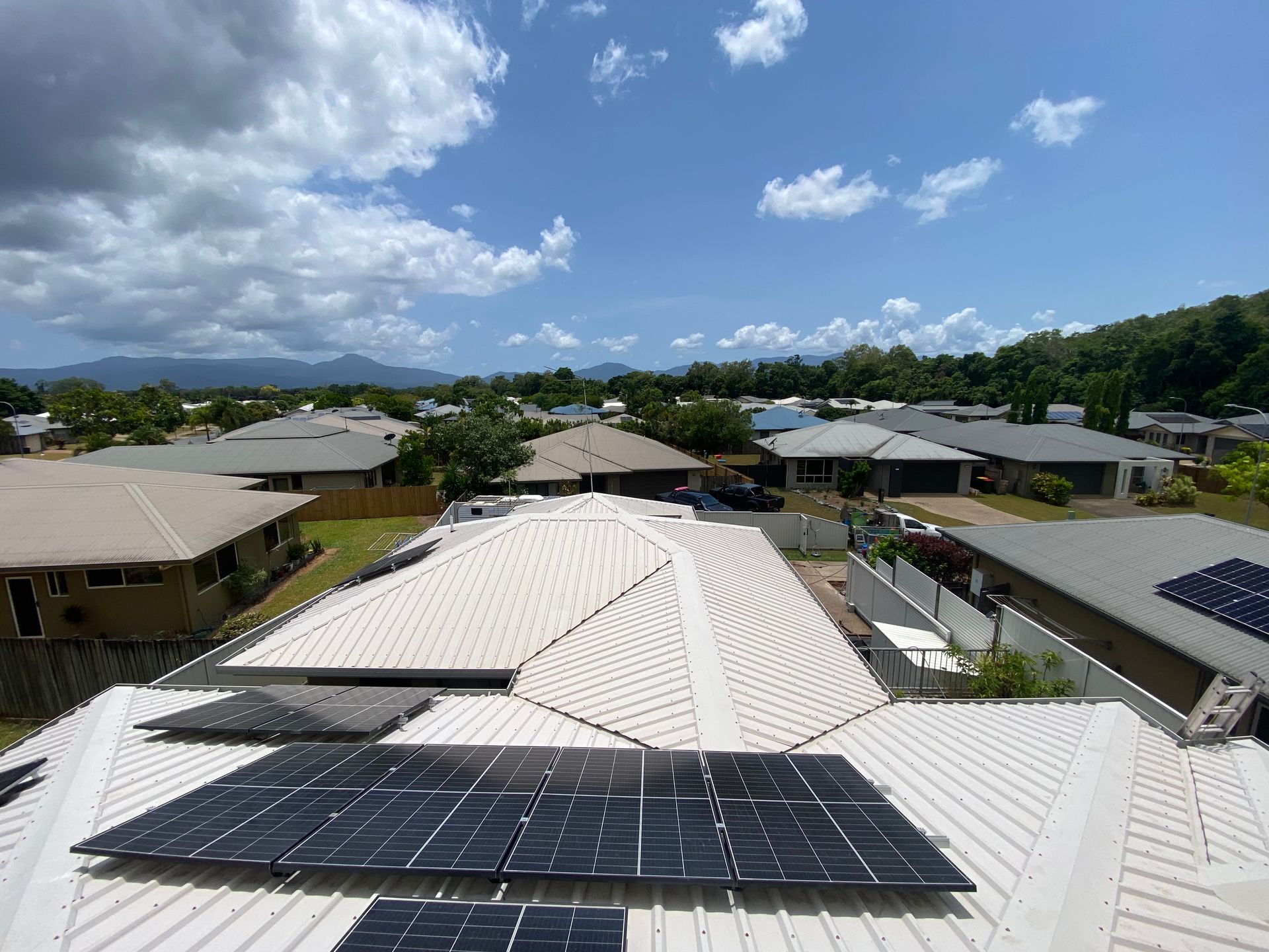 Person in Hard Hat Clean Solar Panels With Pressure Washer — Cairns Bin Cleaning In Parramatta Park, QLD