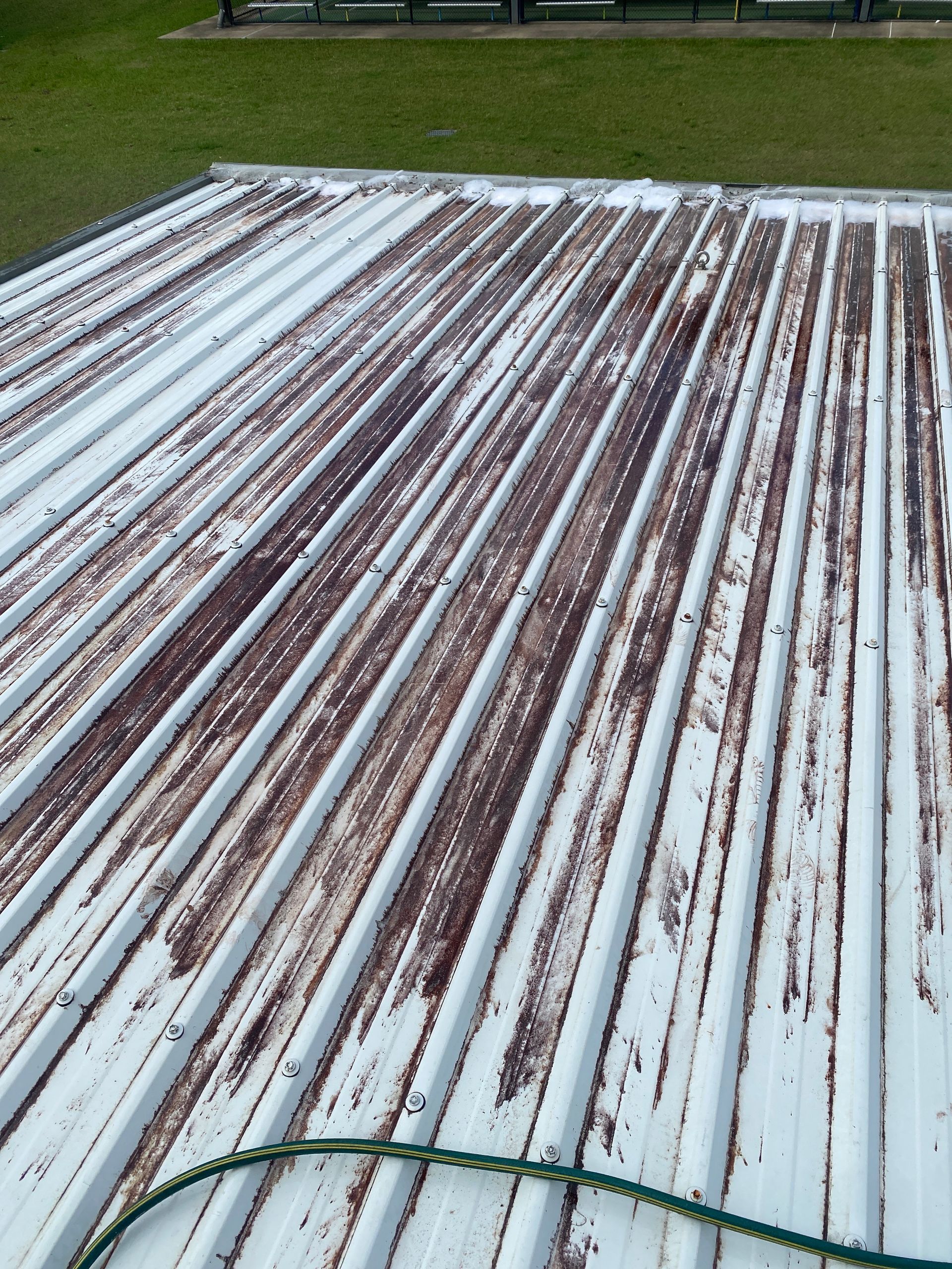 Person on a Roof Using a Power Washer to Clean Orange Tiles — Cairns Bin Cleaning In Parramatta Park, QLD