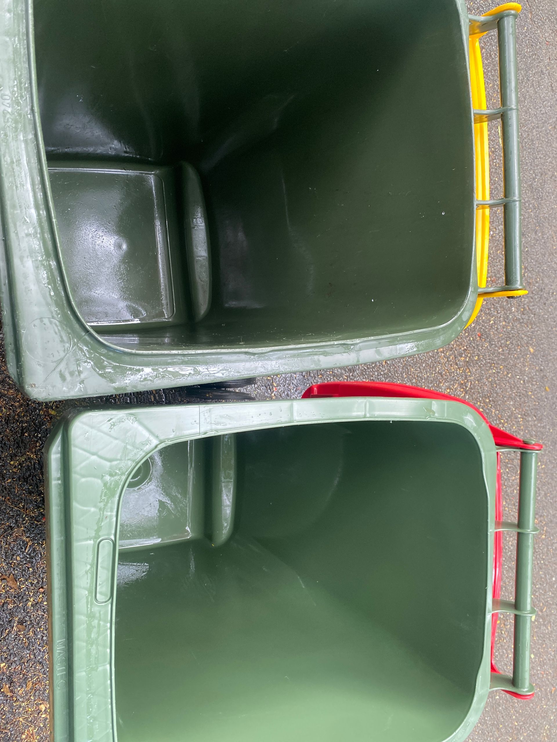 A Person Is Cleaning A Green Trash Can With A High Pressure Washer — Cairns Bin Cleaning In Parramatta Park, QLD
