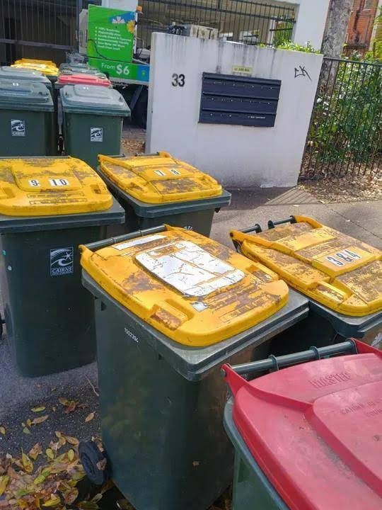 A Group of Recycling Bins Sit Outside a Building — Cairns Bin Cleaning In Parramatta Park, QLD