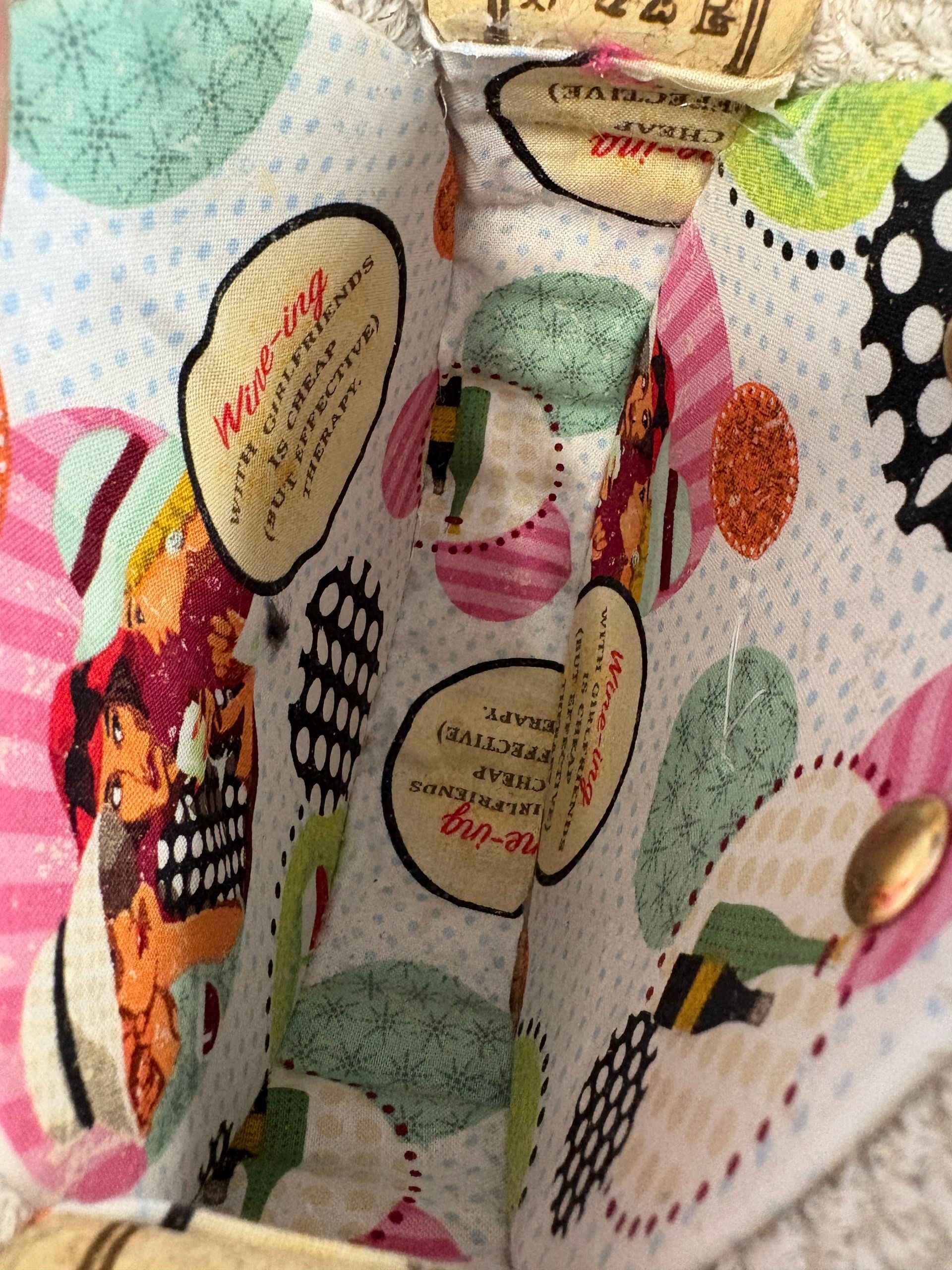 Interior of a fabric tote bag with wine-themed patterns, cork-lined top.
