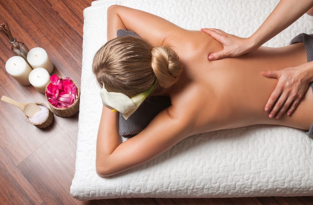 Woman Receiving a Back Massage on A Massage Table — Pink Lily Beauty in Blacksmiths, NSW