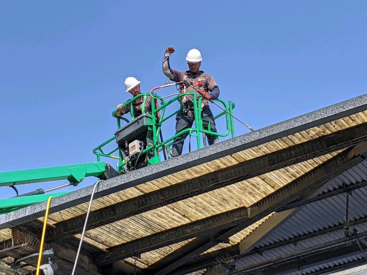 Pinestate Pro Wash owner David Berry on a crane with a coworker washing the roof of the art amphitheater in Raleigh, NC