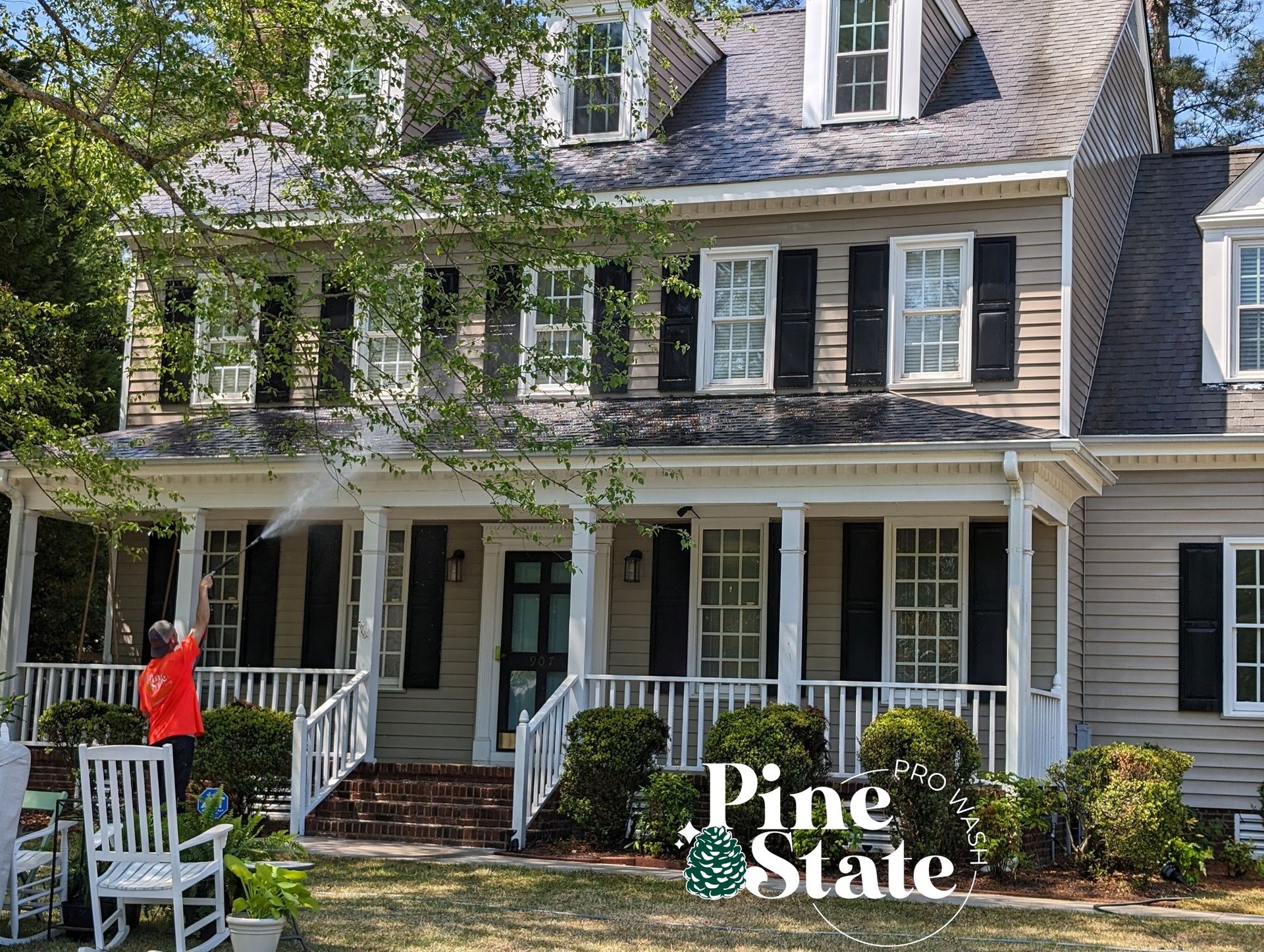 A large house with a large porch and rocking chairs in front of it.