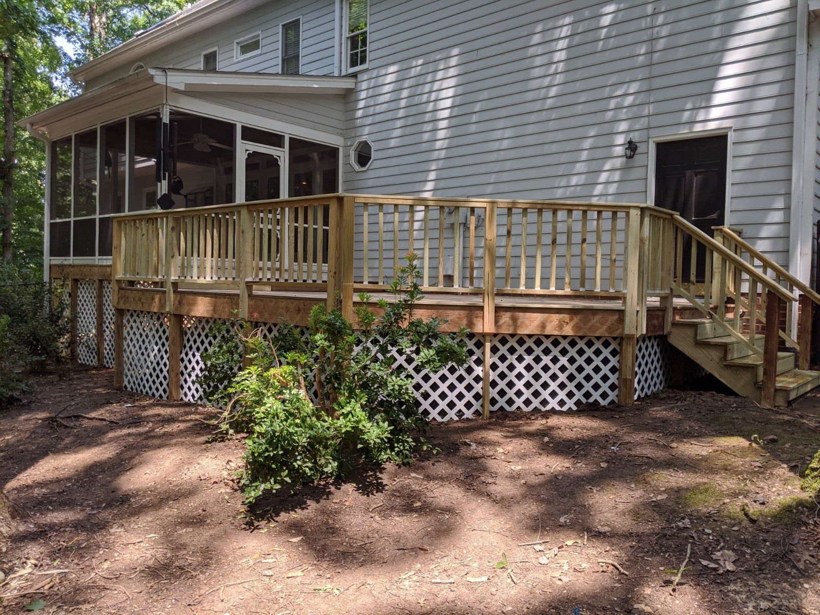 A house with a screened in porch and a wooden deck