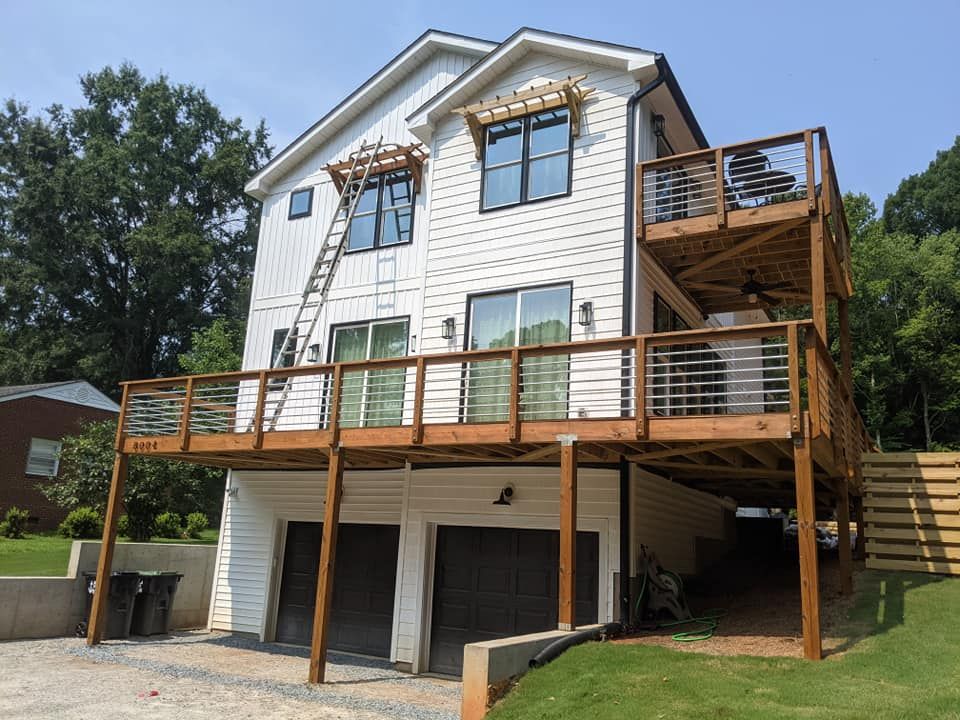 A white house with a wooden deck and stairs