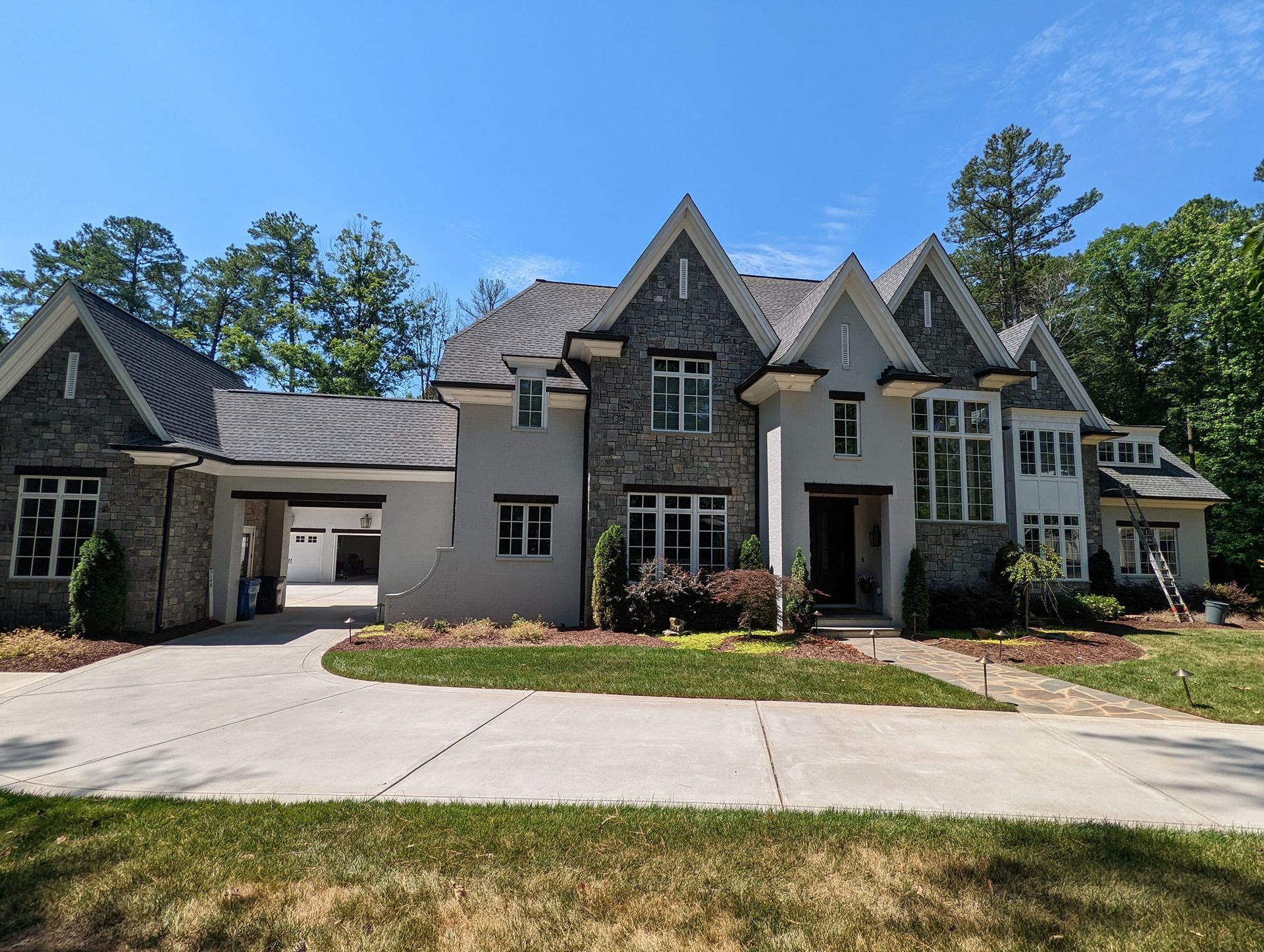 A large house with a lot of windows and a driveway in front of it.