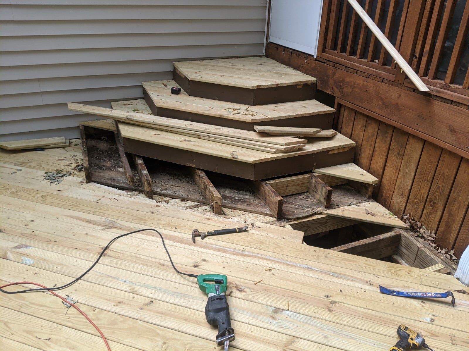 A wooden deck with stairs being built on it.