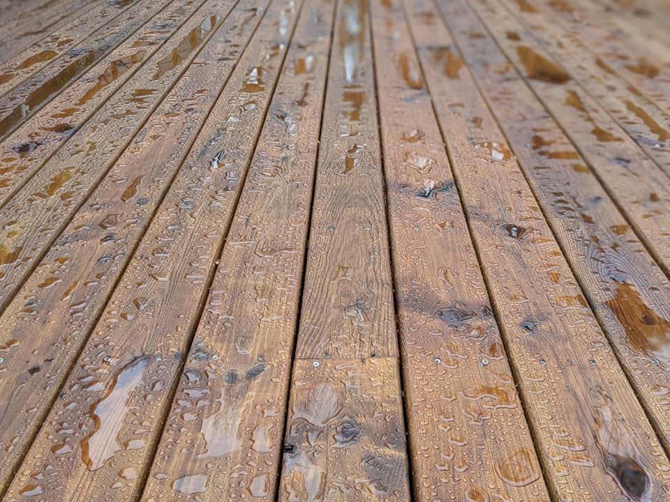 A close up of a wooden deck with water drops on it.