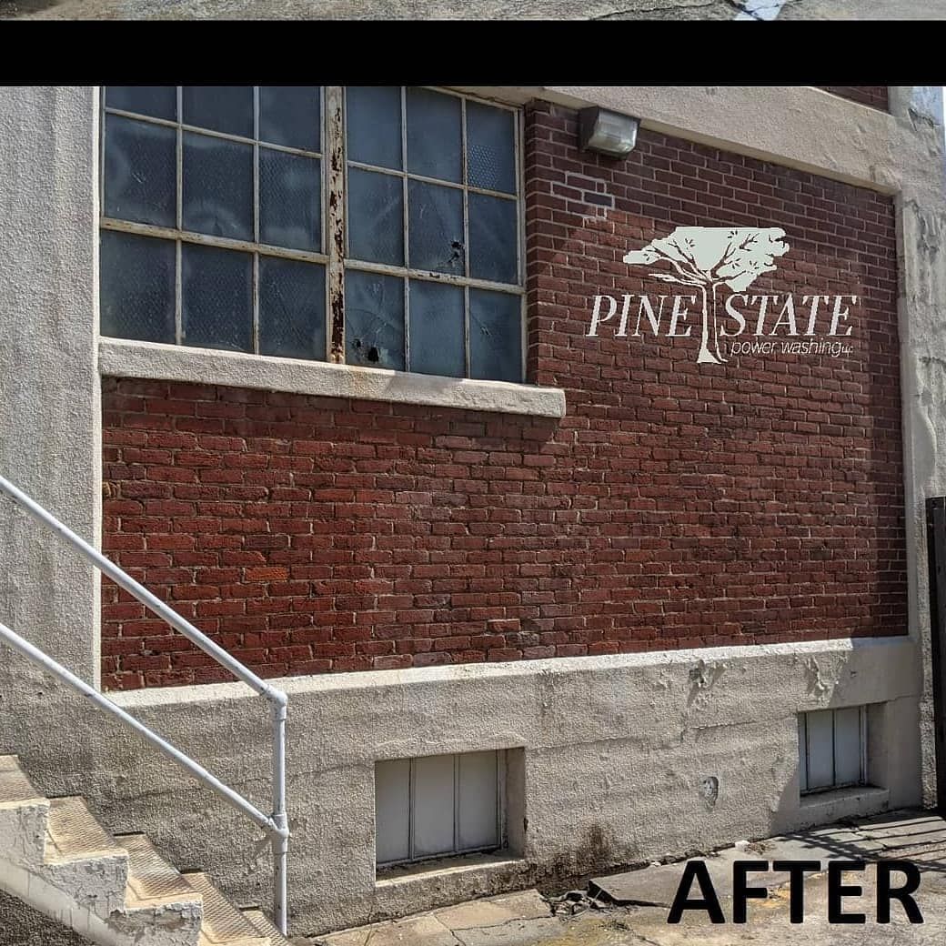 A brick wall with a Pine State logo, a large window, and lower foundation, showing a renovated exterior.