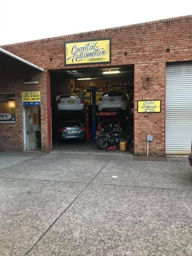 A Brick Building With Cars Parked Inside of It — Coastal Automotive Services Long Jetty in Wamberal, NSW