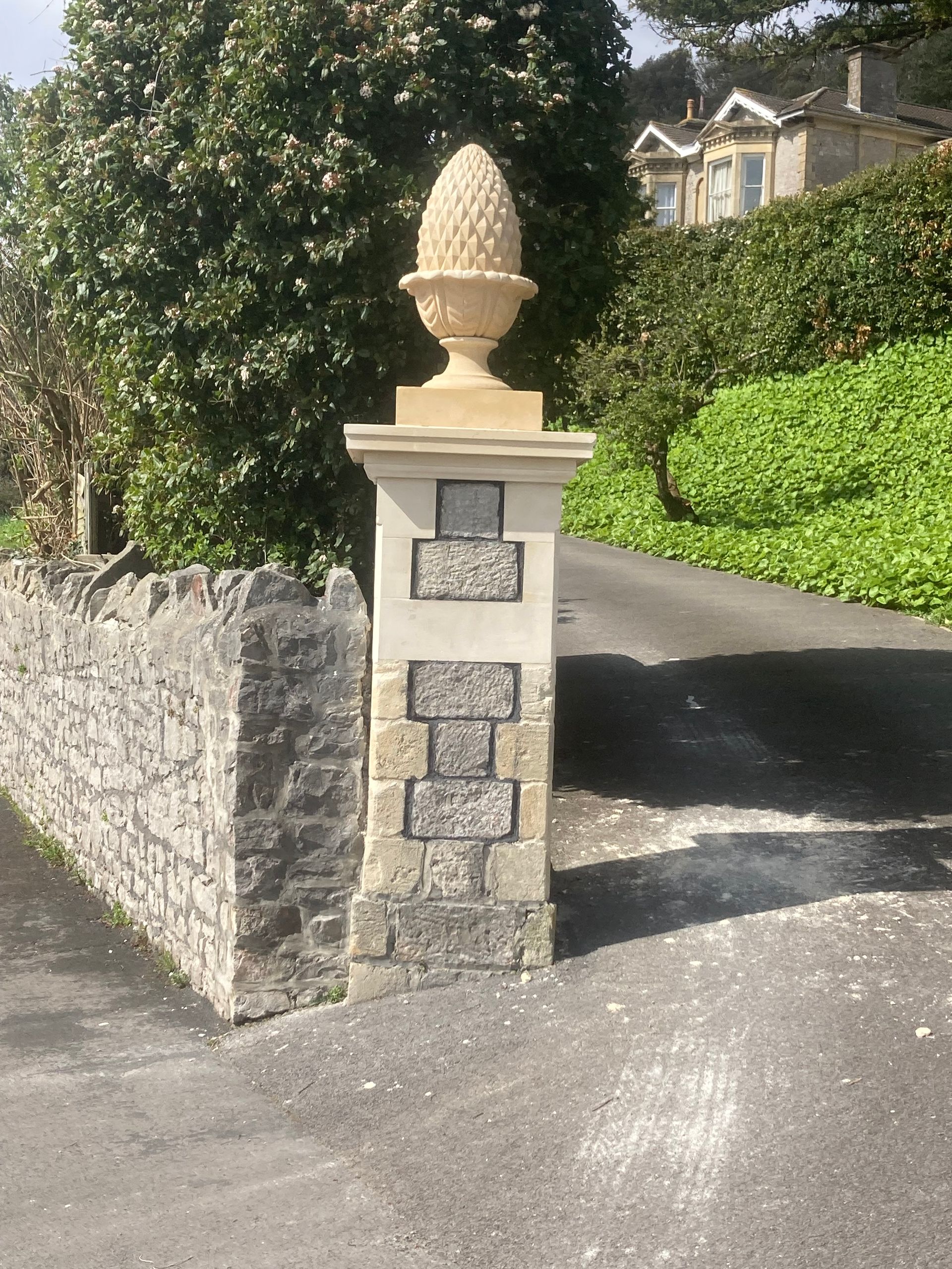 A stone pillar with a pine cone on top of it