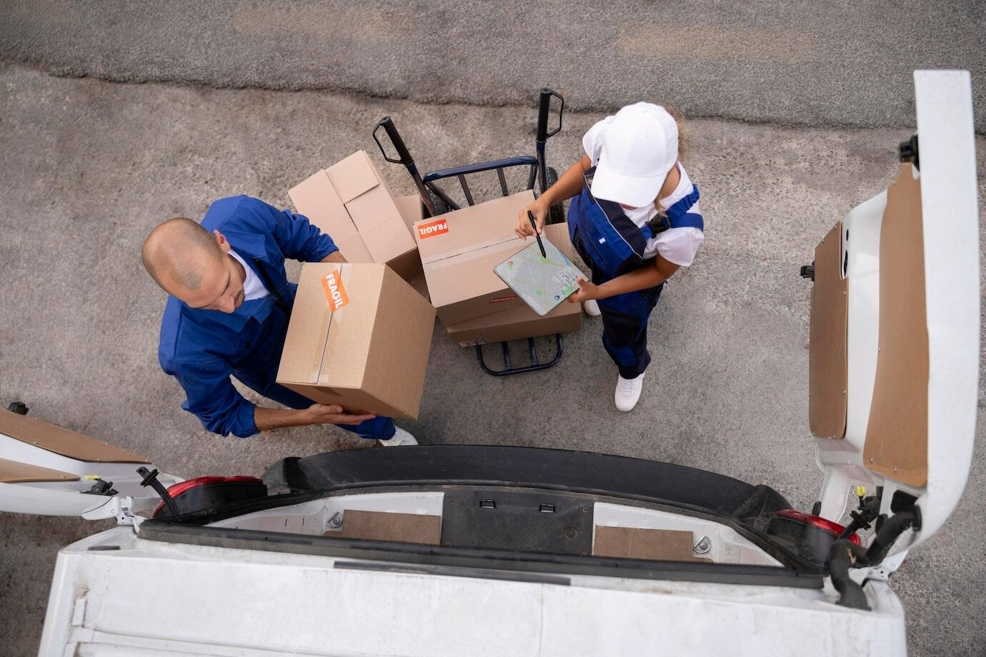 Un hombre y una mujer cargan cajas en una furgoneta.