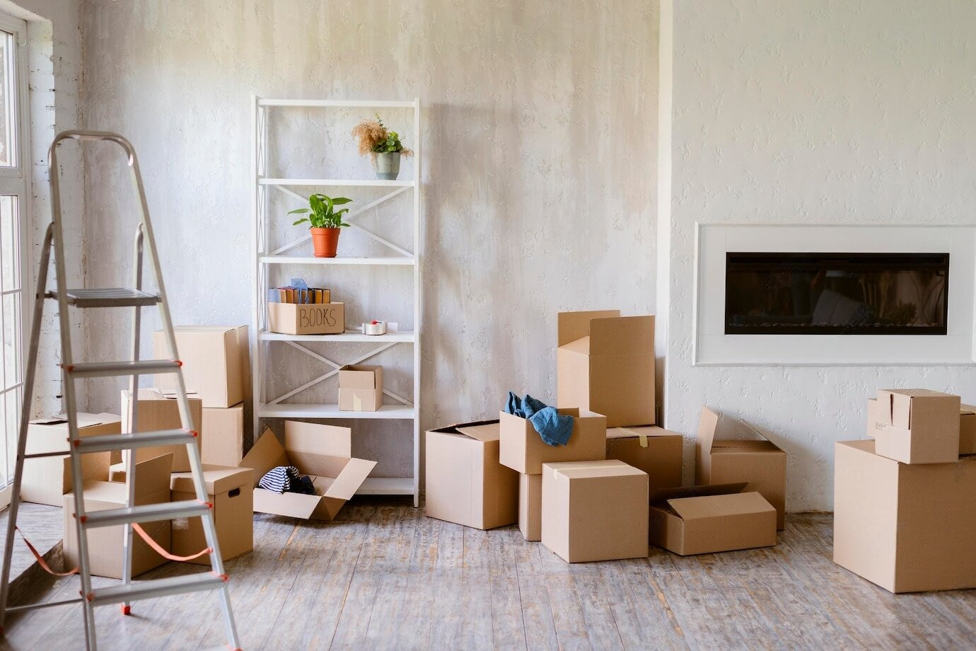 Un salón lleno de cajas de cartón y una escalera.