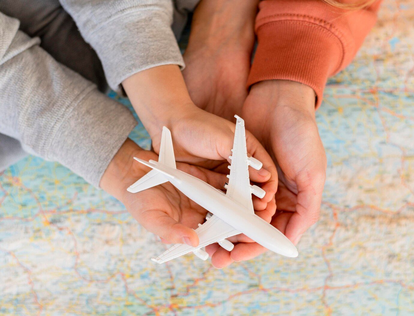 Dos personas sostienen un avión de juguete en sus manos.