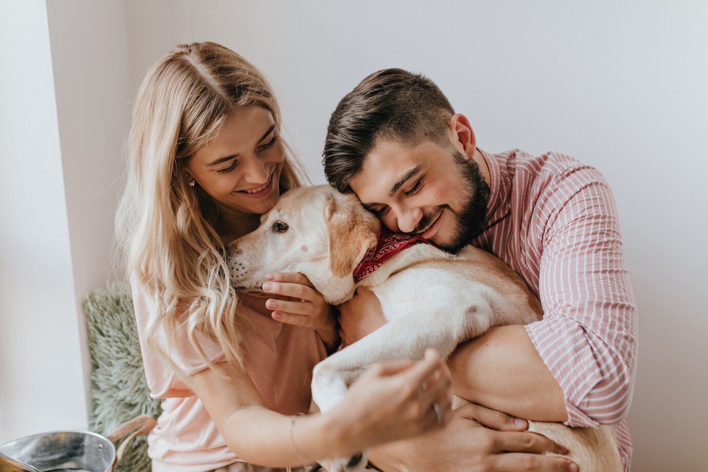 Un hombre y una mujer sostienen un cachorro en brazos.