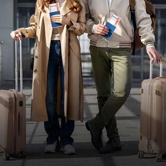 Un hombre y una mujer están uno al lado del otro con equipaje.