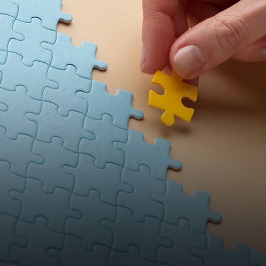 Una persona está poniendo una pieza amarilla en un rompecabezas.