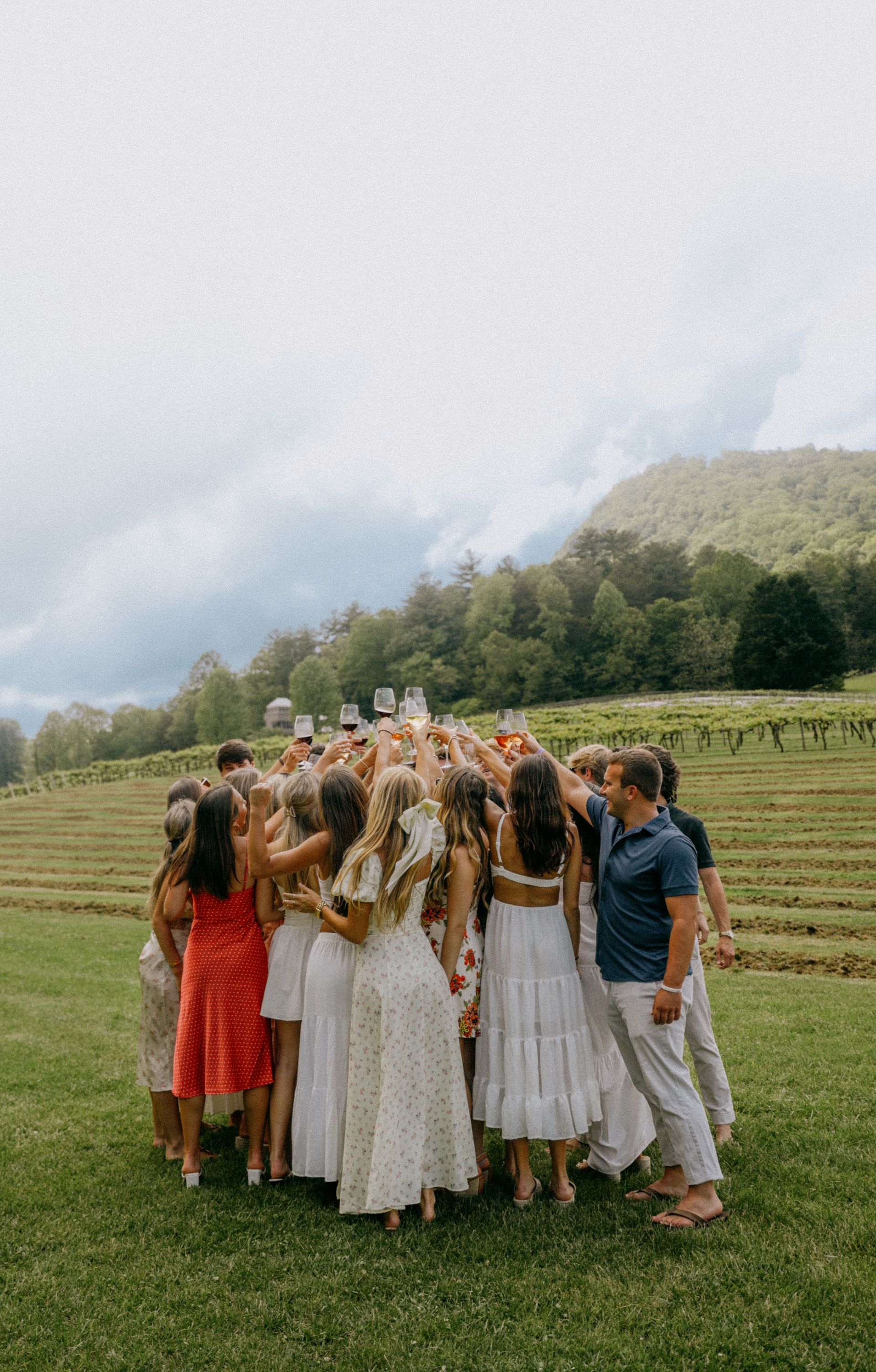 A group of people are standing in a circle in a field.