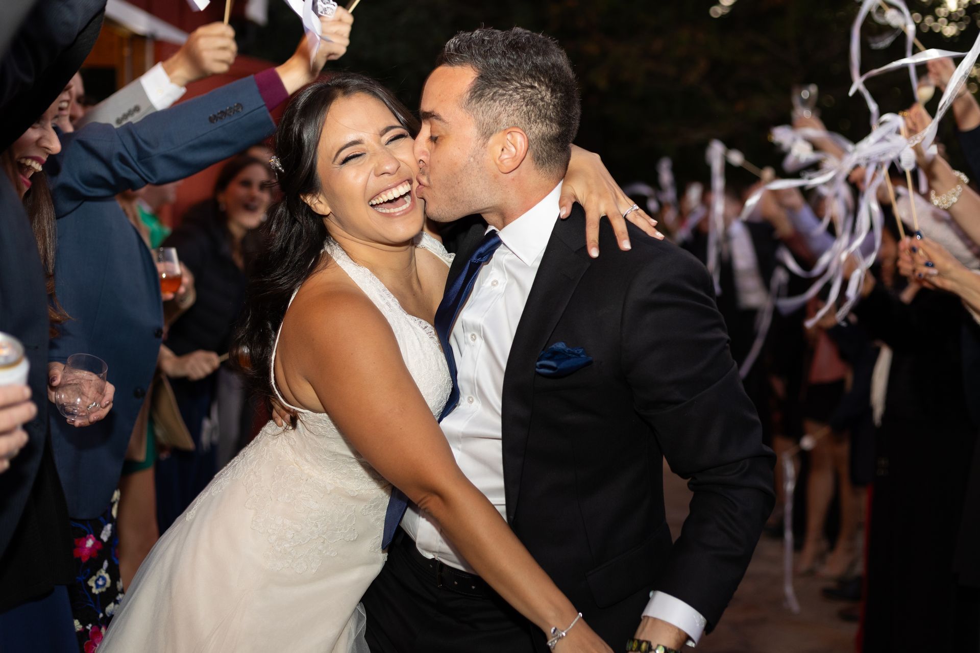 A bride and groom are kissing while dancing at their wedding reception.