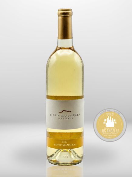 A bottle of wine is sitting next to a coin that says los angeles